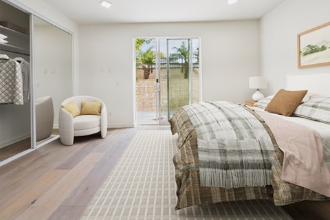 A bedroom with a large bed and a chair.