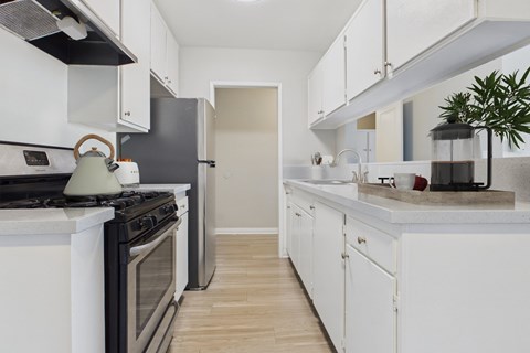 A kitchen with white cabinets and a black stove top.