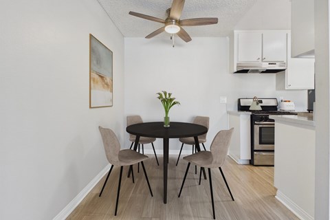 A dining room with a table and chairs.