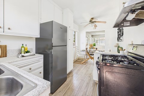 A modern kitchen with a black refrigerator and stove.