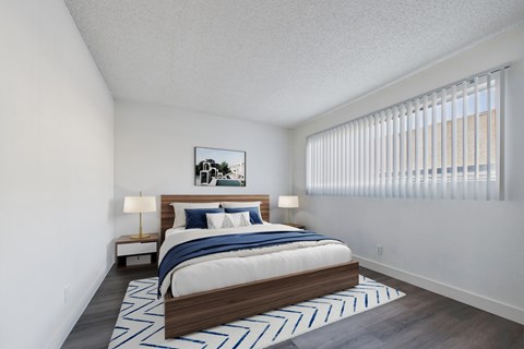 A bedroom with a large bed and a painting on the wall.