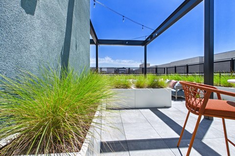 A patio with a chair and a planter box.