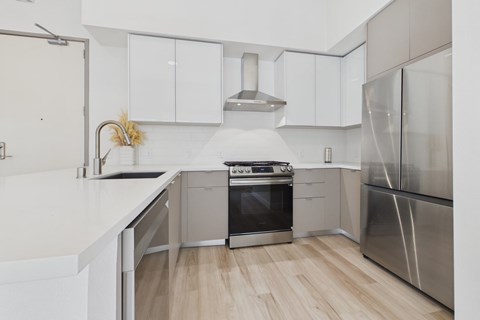 A modern kitchen with stainless steel appliances and white cabinetry.