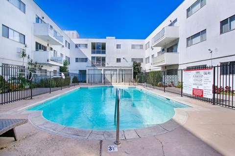 a swimming pool in front of an apartment building