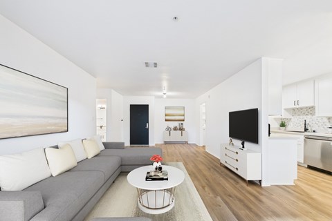 A living room with a grey couch and a white coffee table.