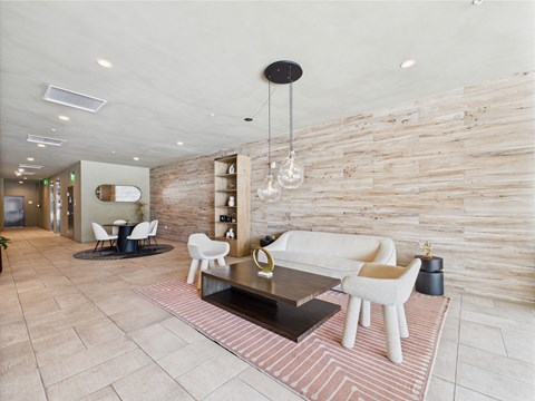 A modern living room with a white couch and a wooden wall.