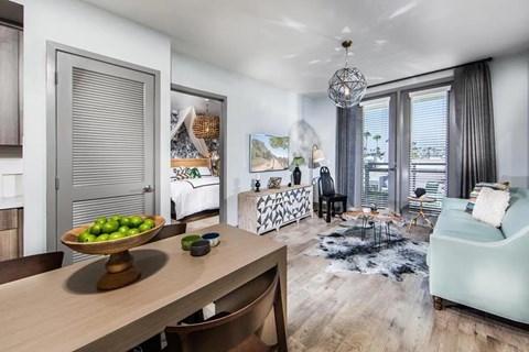 A modern living room with a dining table and chairs.