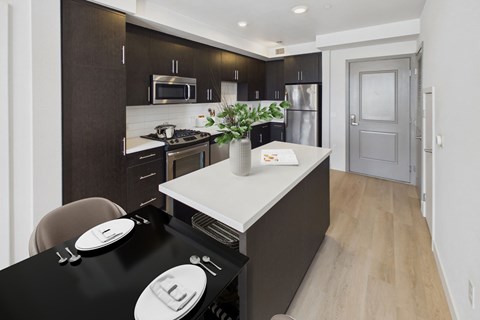 A modern kitchen with dark brown cabinets and a black countertop.