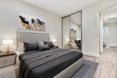 A bedroom with a large bed and a painting on the wall.