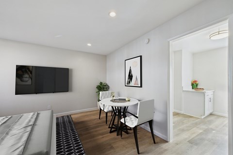 A dining room with a white table and chairs.