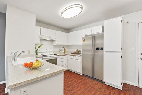 A kitchen with white cabinets and a granite countertop.