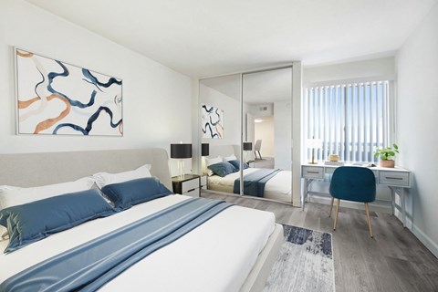 A bedroom with a large bed and a painting on the wall.