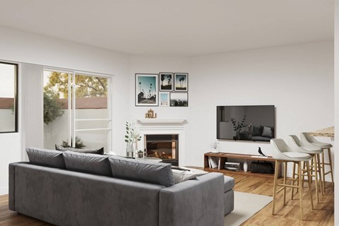 A grey couch sits in front of a fireplace in a modern living room.