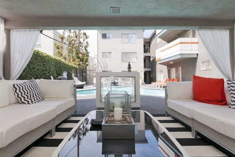 A modern living room with a pool table and a glass table with candles on it.