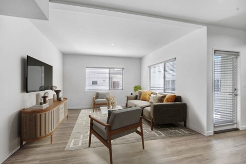 A modern living room with a wooden chair and a grey sofa.