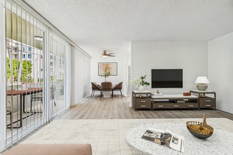 A living room with a television, a chair, a table, and a bowl on the coffee table.