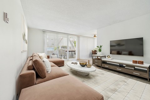 A living room with a brown couch and a flat screen TV.