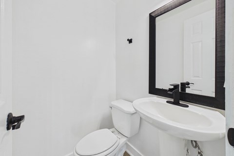 A white toilet and sink in a bathroom.