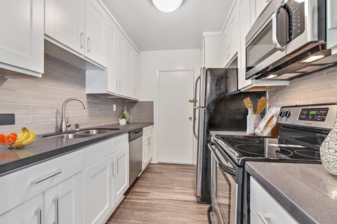 A kitchen with white cabinets and a black stove top oven.