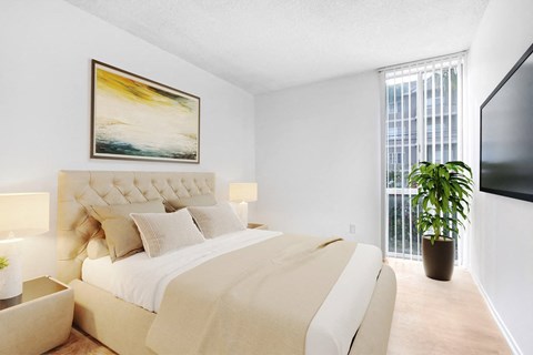 A bedroom with a large bed and a painting on the wall.
