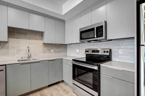 A modern kitchen with a stainless steel oven and microwave.