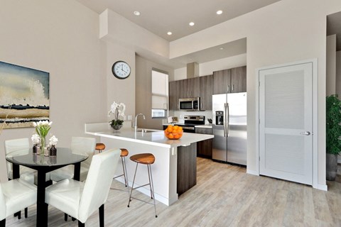 A modern kitchen with a dining table and chairs.