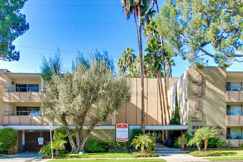 A modern building with a red sign in front.