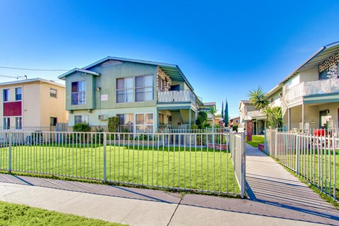A row of houses with a metal fence in front.