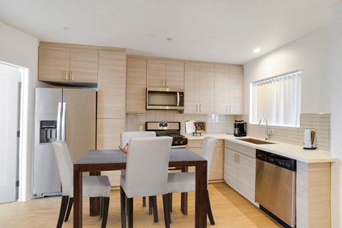 A modern kitchen with a dining table and chairs.
