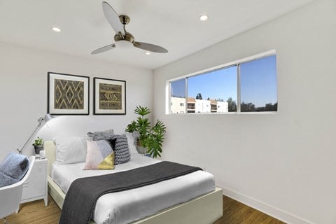 A bedroom with a large bed and a ceiling fan.