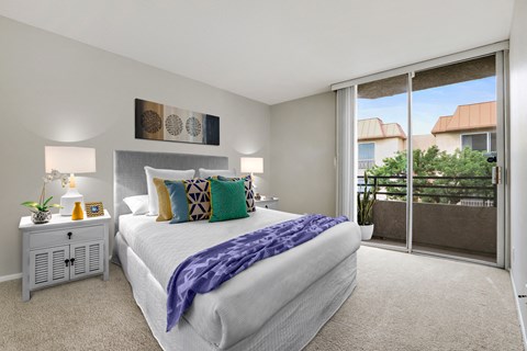 A bedroom with a large bed and a view of the outside.