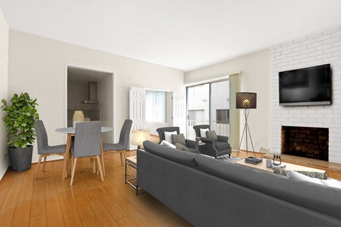 A living room with a grey couch, a fireplace, and a television mounted on the wall.