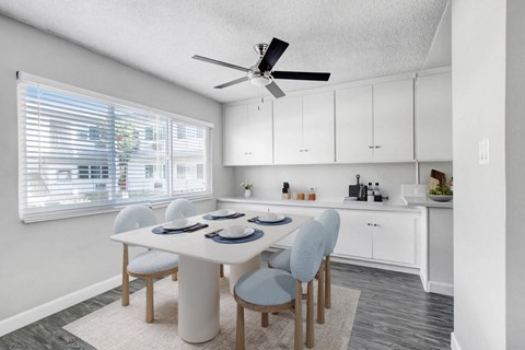 a dining room with a table and chairs and a ceiling fan