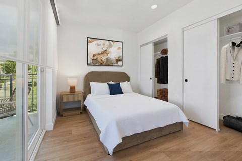 A bedroom with a large bed and a painting on the wall.