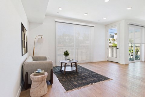 A living room with a chair, ottoman, and table.