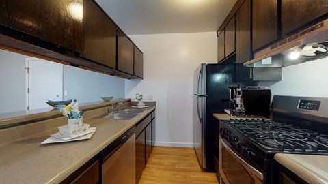 A kitchen with a black stove top oven and a black refrigerator.