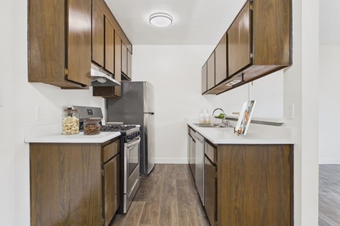 A kitchen with wooden cabinets and a stainless steel refrigerator.