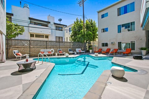 A swimming pool with a sun lounger and a table.