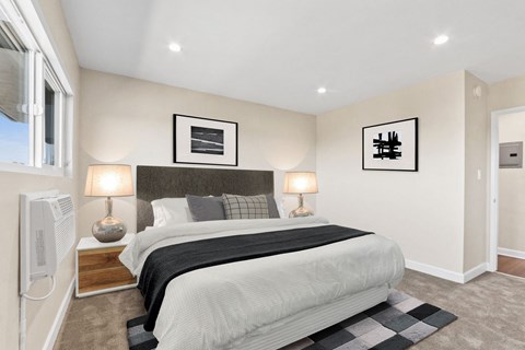 A bedroom with a large bed and two lamps.
