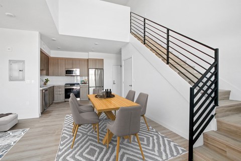 A modern dining room with a wooden table and grey chairs.