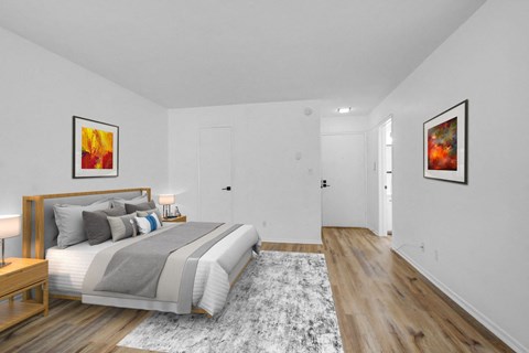 A bedroom with a large bed and two framed pictures on the wall.