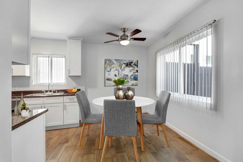 A kitchen with a dining table and chairs.