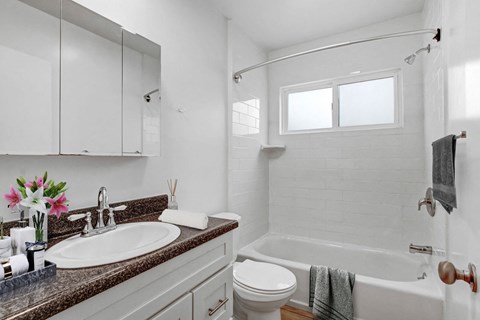 A white bathroom with a sink, toilet, and bathtub.
