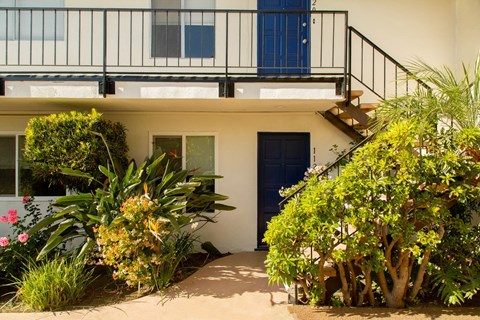 the front of a house with a staircase and a blue door