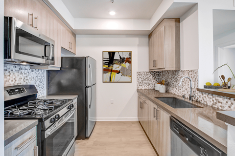 A kitchen with a black stove top oven and a black refrigerator.