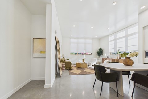A dining room with a white table and chairs.