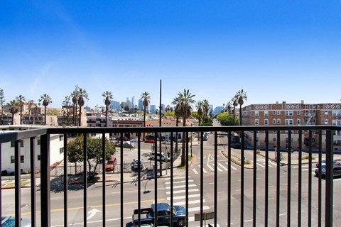 a balcony with a black railing and a city in the background