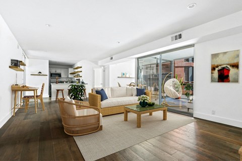 A living room with a white couch and a wooden floor.