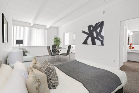 A bedroom with a large bed and a chair.