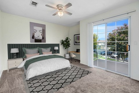 A bedroom with a large bed and a ceiling fan.